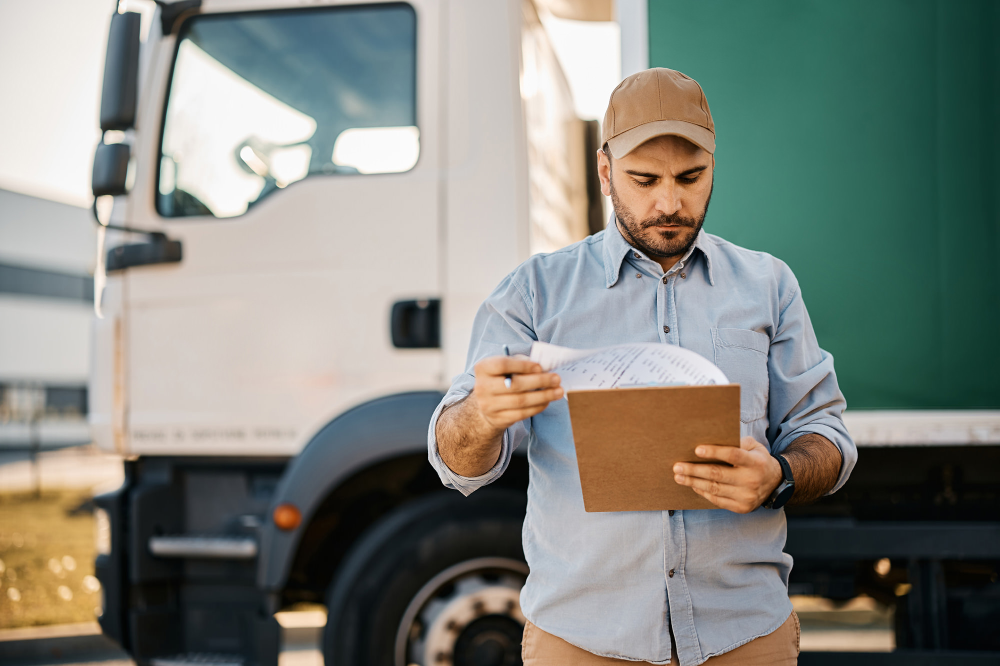 a man holding a paper in front of a truck