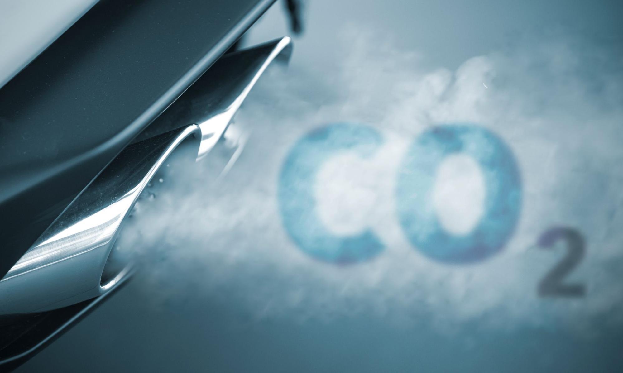 close-up do escapamento do carro e da fumaça saindo dele soletra a palavra CO2