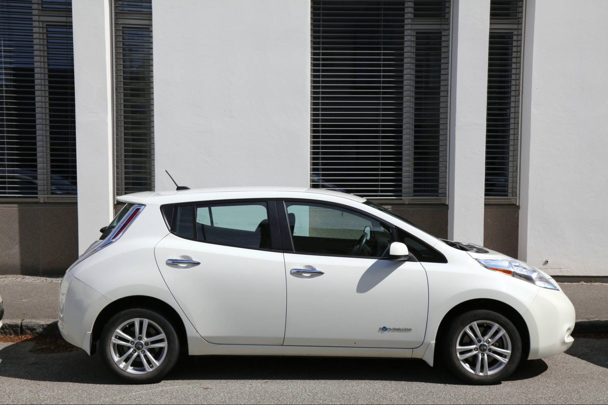 Электрический компактный автомобиль Nissan Leaf с нулевым уровнем выбросов припаркован на улице