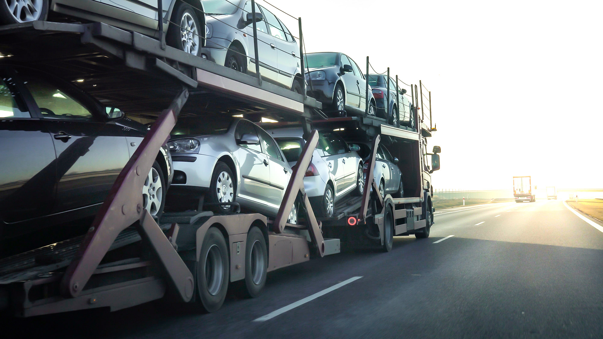 8 passenger cars being transported on a truck.