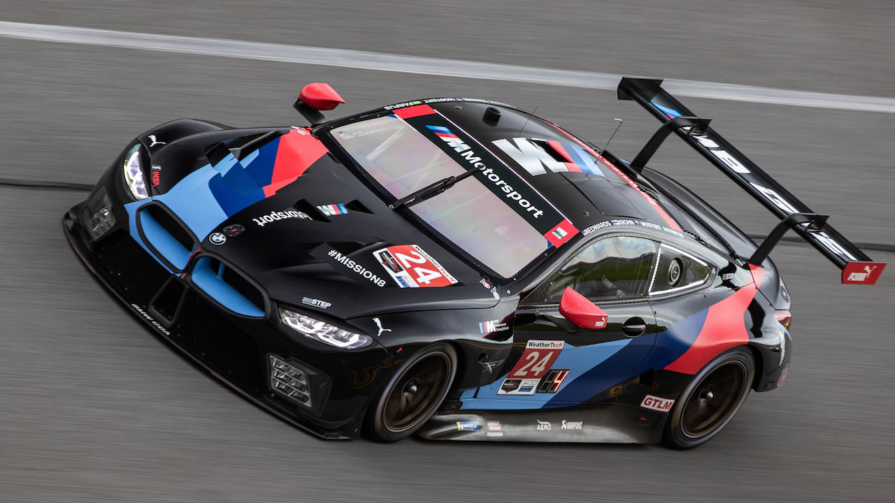 Modern BMW racing car on a track. The vehicle is a sleek, aerodynamic sports car with BMW's distinctive livery in black, blue, and red colors.