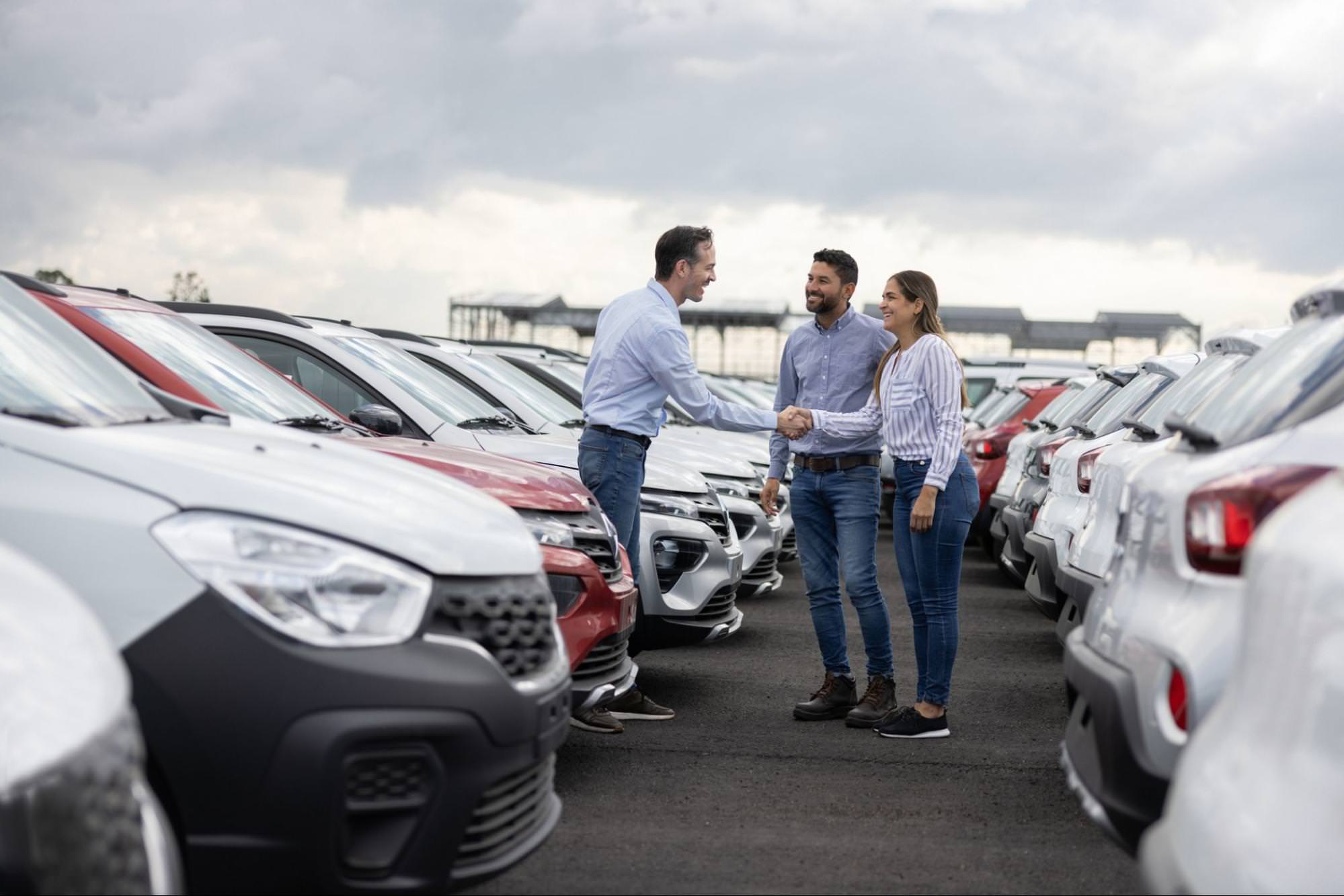 This scene depicts the closing of a car deal, showcasing successful customer interaction and relationship-building in a sales environment.