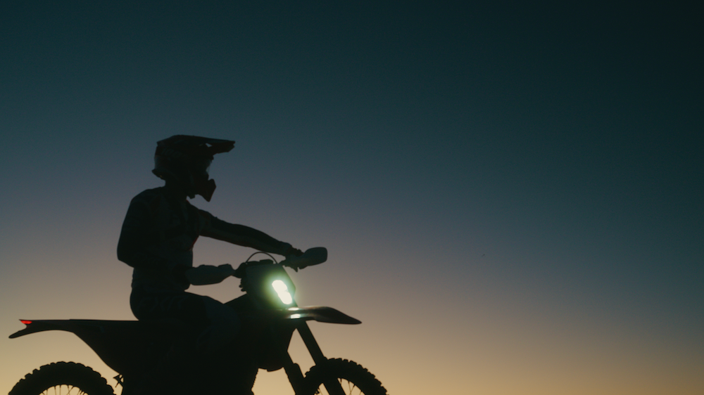 A rider on the Stark VARG EX silhouetted against a fading Arizona sky.